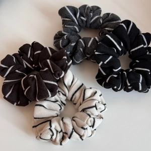 Vue détaillée de quatre chouchous en tricot rayé en chocolat, gris, noir et crème