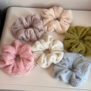 Vista piatta di sei elastici per capelli colorati in maglia peluche dai toni pastello