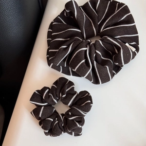 Détail de chouchous en maille rayée marron foncé en tailles large et petite, texture douce
