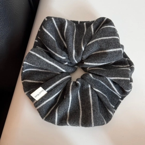 Vue détaillée du chouchou en maille rayée gris foncé avec étiquette textile Hand Made