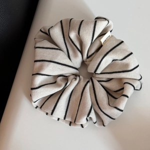 Détail d'un grand chouchou en maille rayée avec une étiquette tissée Hand Made