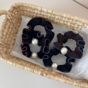 Detailed macro view of vintage pleated pearl scrunchies in stylish color combinations
