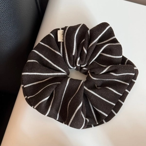 Détail d'un chouchou en maille rayée marron café avec étiquette tissée Hand Made