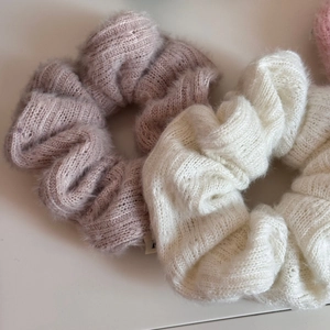 Texture dettagliata di elastici per capelli in peluche lavorato a maglia rosa e panna
