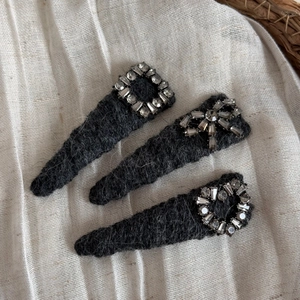 Détail de barrettes en peluche grise avec strass en forme de cœur, nœud et carré