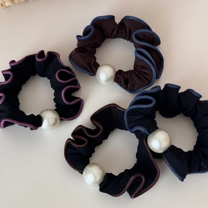 Detail of four pleated hair scrunchies with contrast edges and large decorative pearls