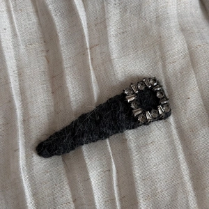 Vue détaillée de la pince à cheveux en peluche noire avec cristal carré étincelant chic