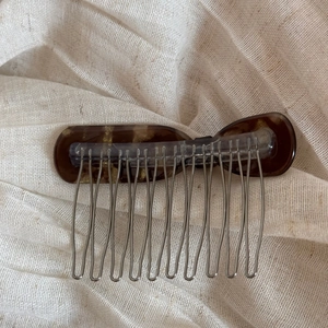 Détail du peigne à cheveux nœud en écaille avec taches dorées et dents en métal argenté