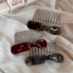 Vue détaillée de trois peignes à cheveux en acétate avec nœuds aux motifs écaille et marbre