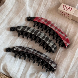 Detail of plaid acetate banana hair clips with strong grip teeth for thick hair styling