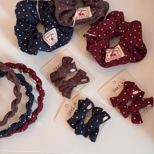 Detailed set of polka dot fabric hair ties and bows in navy, brown, and wine red
