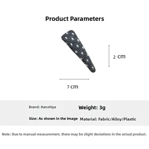 Detailed view of grey polka dot fabric triangular hair clip with 7x2cm dimensions