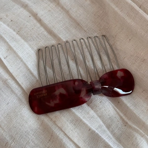 Détail du peigne à cheveux nœud en écaille bordeaux avec gravure dorée fait main