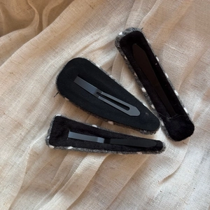 Detailed view of three knitted polka dot hair clips with secure metal BB backing