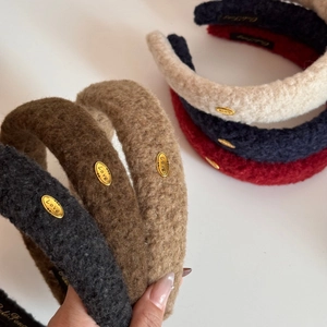 Detailed view of plush teddy fabric headband with elegant gold Love metal tag