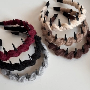 Close-up of cable knit headbands with teeth in wine red, black, grey, cream, and coffee
