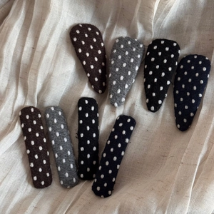 Close-up of polka dot fabric BB hair clips and barrettes in various neutral colors