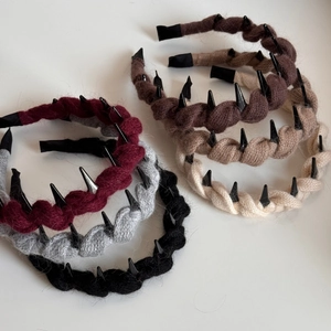 Detailed close-up of colorful knitted twist headbands with punk-style black spikes