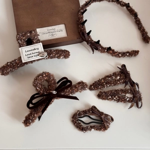 Détails d'accessoires de cheveux en tweed marron avec nœuds en velours et perles
