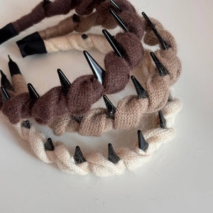 Close-up of knit braided headbands with punk studs in coffee, tan and beige colors