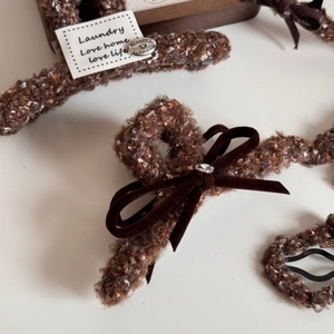 Détail de la pince à cheveux en tweed marron avec nœud en velours et cristaux