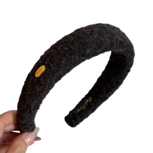Chic black fuzzy plush headband with gold Love metal tag for elegant winter hair styling