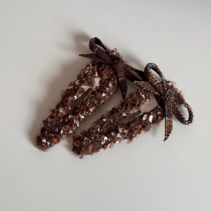Détail de pinces à cheveux à nœud en tweed marron avec texture mouchetée hivernale