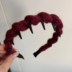 Detail shot of wine red knitted cable pattern headband with black non-slip inner teeth