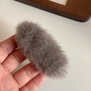 Detail showing the soft texture and fluffy gray faux fur of this triangular plush hair clip