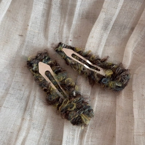 Detailed macro of vintage knit yarn wrapped hair clips in earthy mixed colors