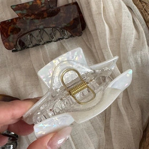 Detail showing acetate hair claws in tortoiseshell and iridescent white finishes