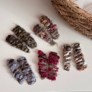 Detail showing colorful knit wool hair clips in various gradient textures and patterns