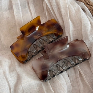 Close-up of tortoiseshell and translucent amber acetate hair claws with Barrette la France text
