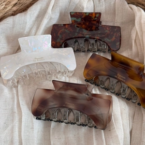 Detail showing four assorted acetate hair claws in tortoise shell and marble patterns