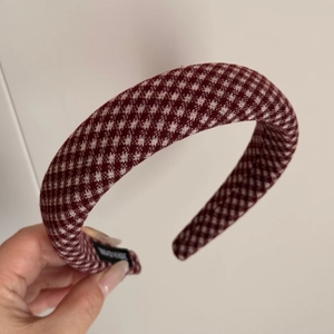 Detailed close-up of a handmade plaid sponge headband with burgundy checkered fabric