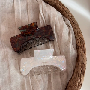 Detail of tortoise and pearlescent acetate hair claws with gold Barrette la France script