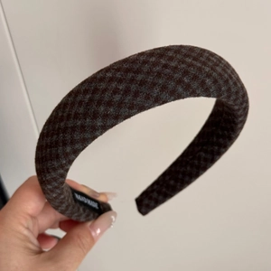 Close-up of thick checkered sponge headband with handmade label and wool texture