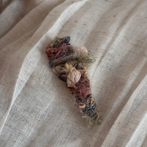 Detailed view of the gradient woven yarn texture on a handmade winter knit hair clip