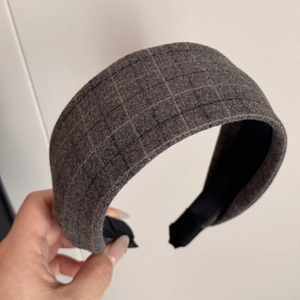 Detailed macro view of the grey plaid fabric texture on a wide thick padded headband