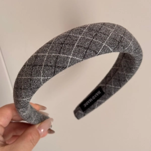 Detailed macro of grey quilted fabric headband featuring white stitch diamond patterns
