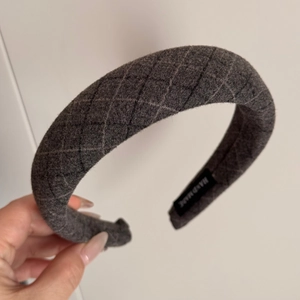 Detail of grey diamond pattern padded headband with textured wool and Hand Made label