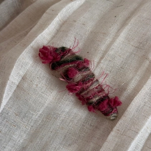 Close-up of handmade gradient yarn hair clip with soft fringe and knit texture