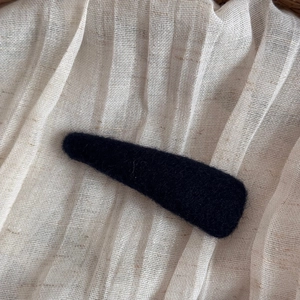 Detailed view of the black fuzzy texture on the teardrop-shaped felt hair clip