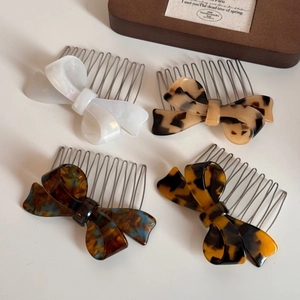 Set of four acetate bow hair side combs with tortoiseshell and marble patterns