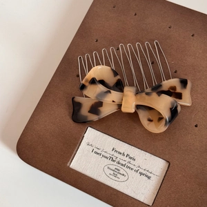 Detail of French vintage tortoiseshell acetate bow hair comb with silver metal teeth