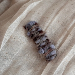 Detail of soft gradient wool knit hair clip featuring brown and purple mohair textures