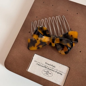 Macro detail of French vintage tortoiseshell acetate bow hair comb with silver metal teeth