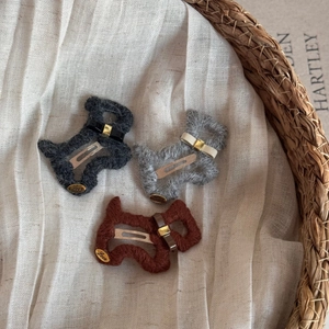 Detailansicht der niedlichen Plüsch-Hunde-Haarklammern mit Lederschleifen und Metall-Charms