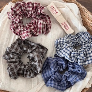 Set of four vintage plaid scrunchies in various colors displayed in a woven basket