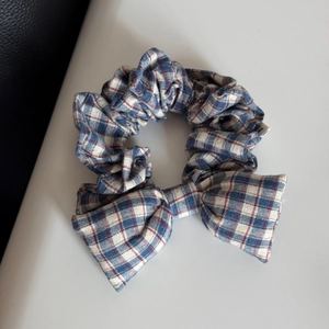 Detail of red and blue plaid bow scrunchie with elastic band and fabric texture